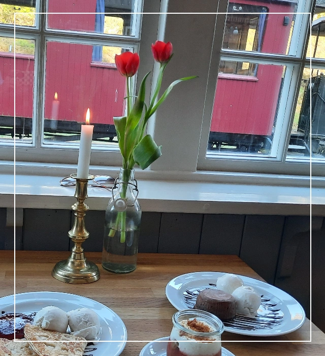 Candlelit dinner - Et billede af dessert samt lysestage med levende lys og to tulipaner